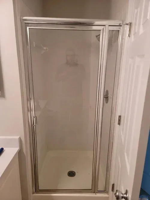 A bathroom with a shower stall with a clear glass door.