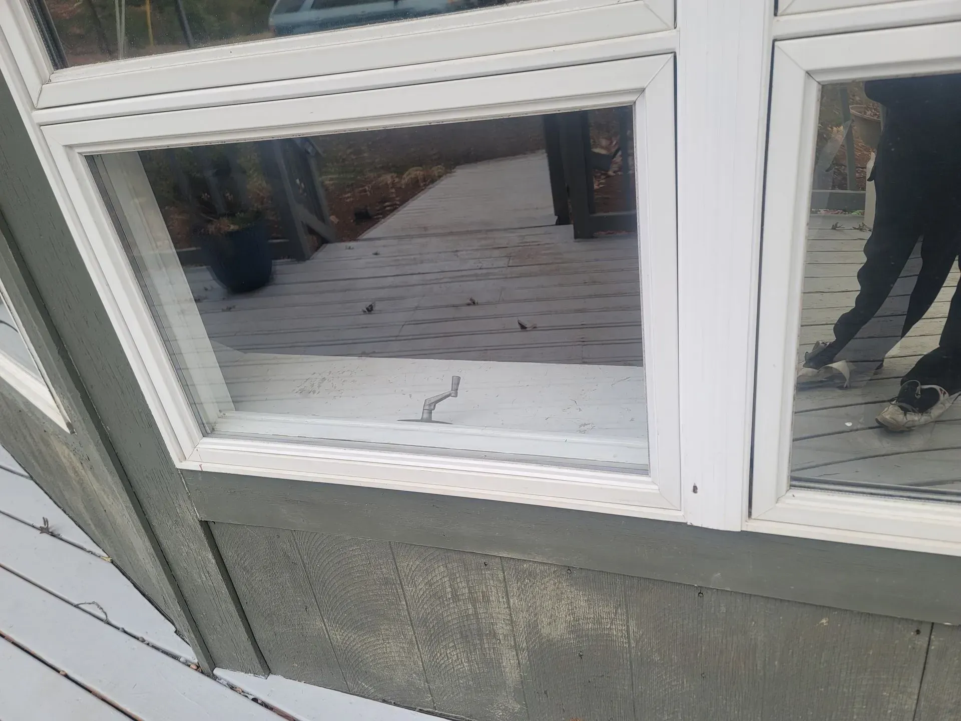 A person is standing in front of a window on a house.