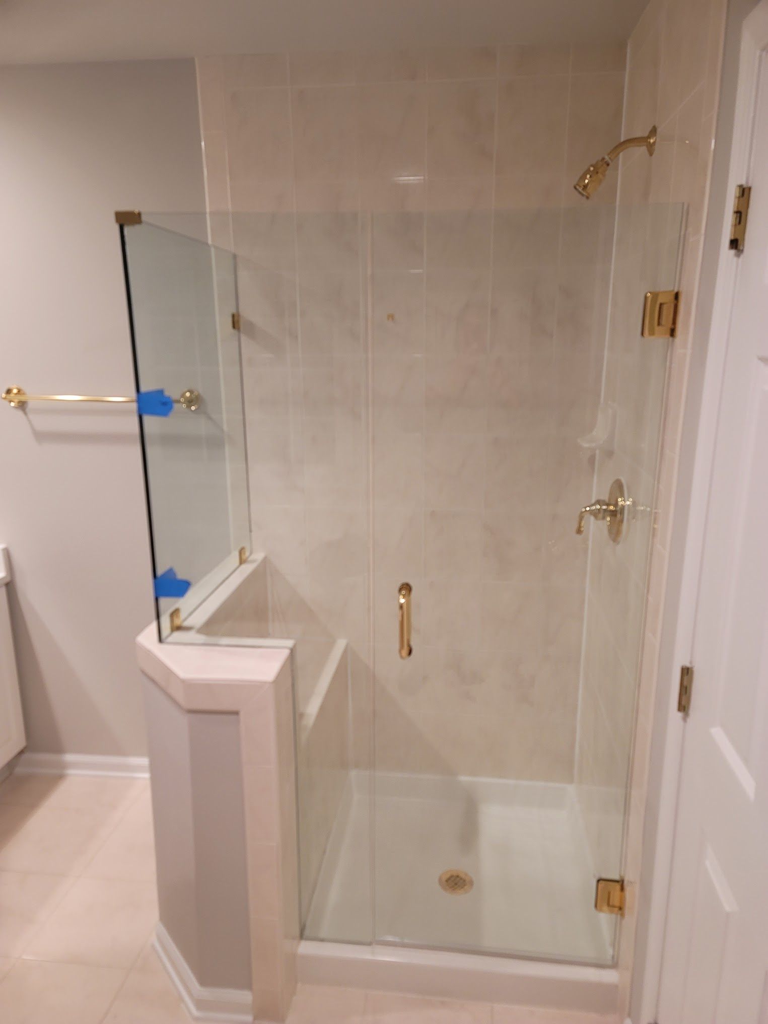 A bathroom with a walk in shower with a glass door.