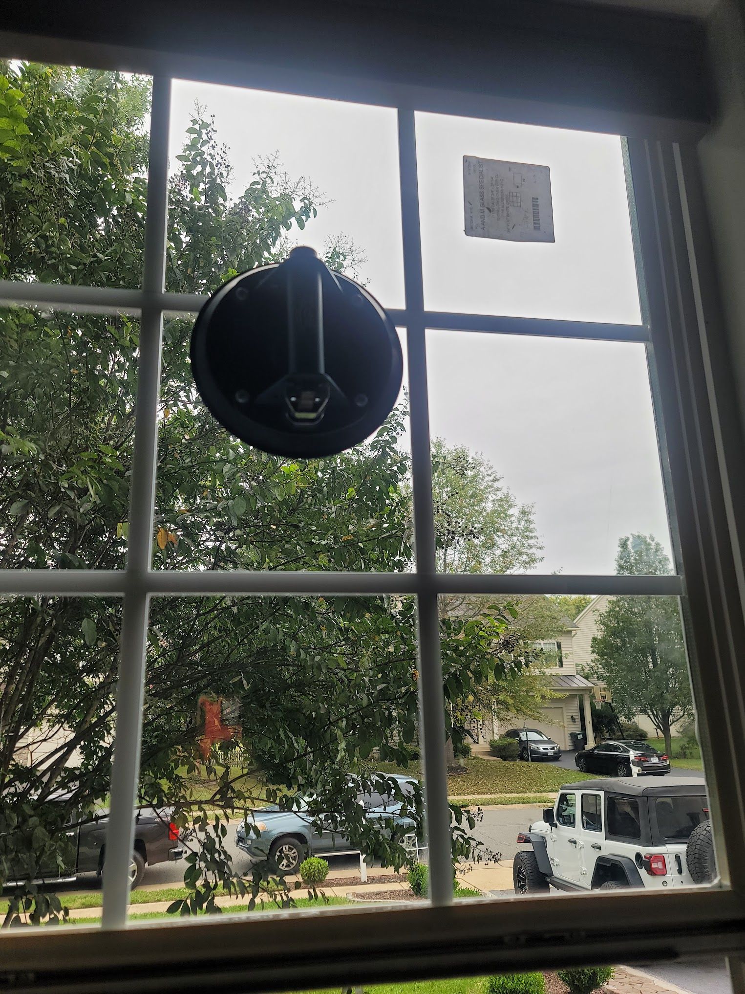 A window with a black object hanging from it.