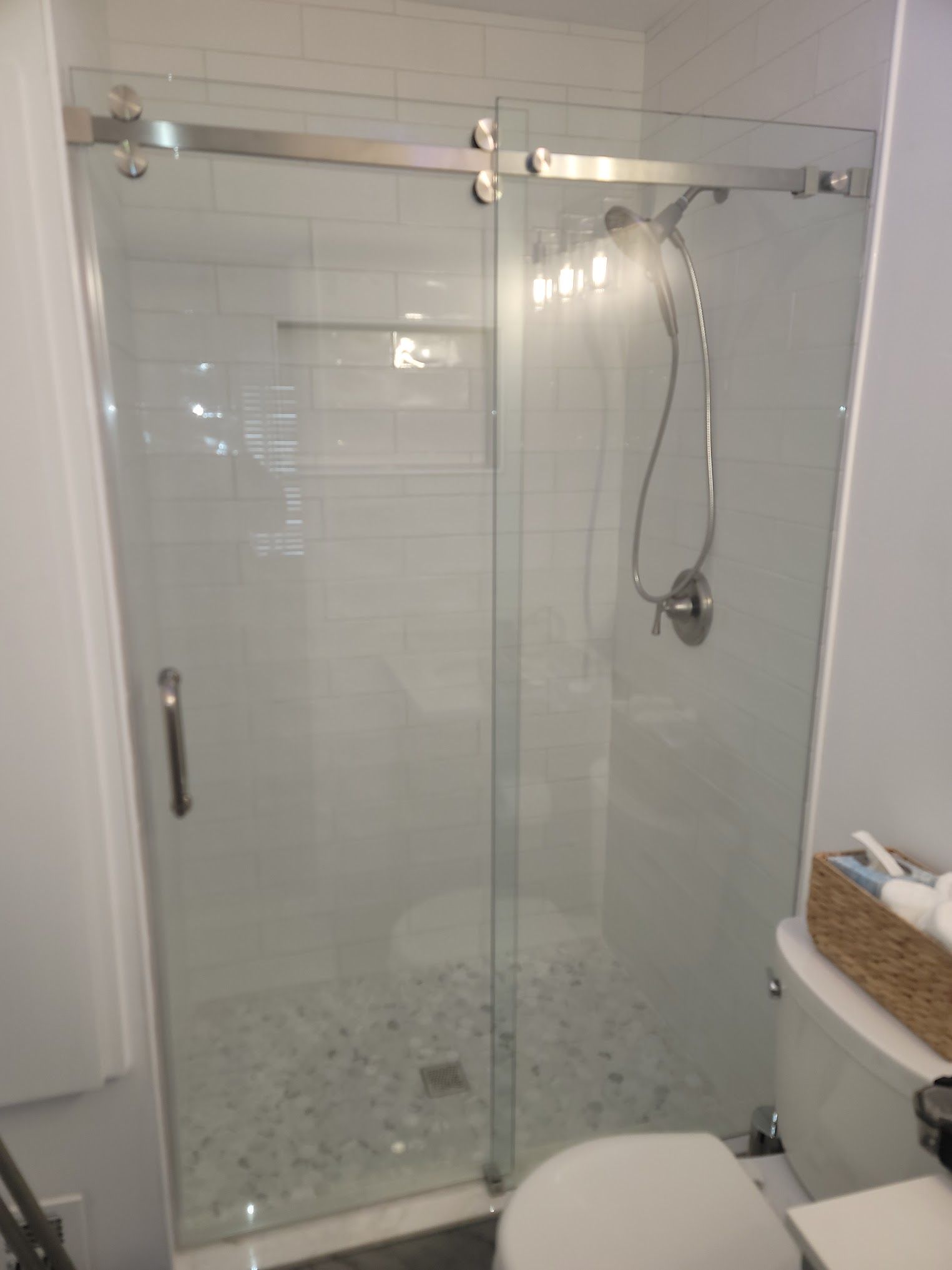 A bathroom with a sliding glass shower door and a toilet.