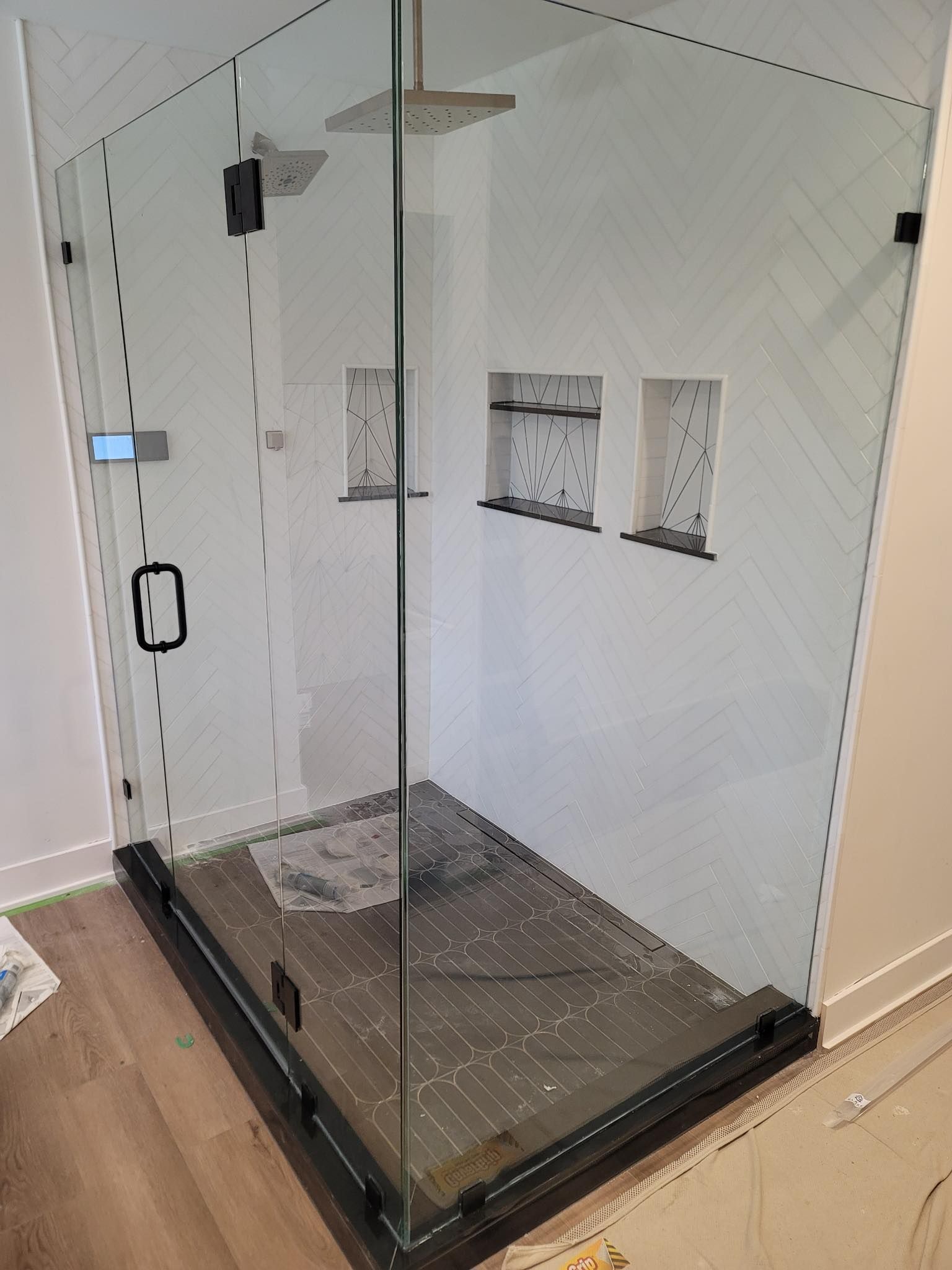 A shower stall with a glass door and a black frame in a bathroom.