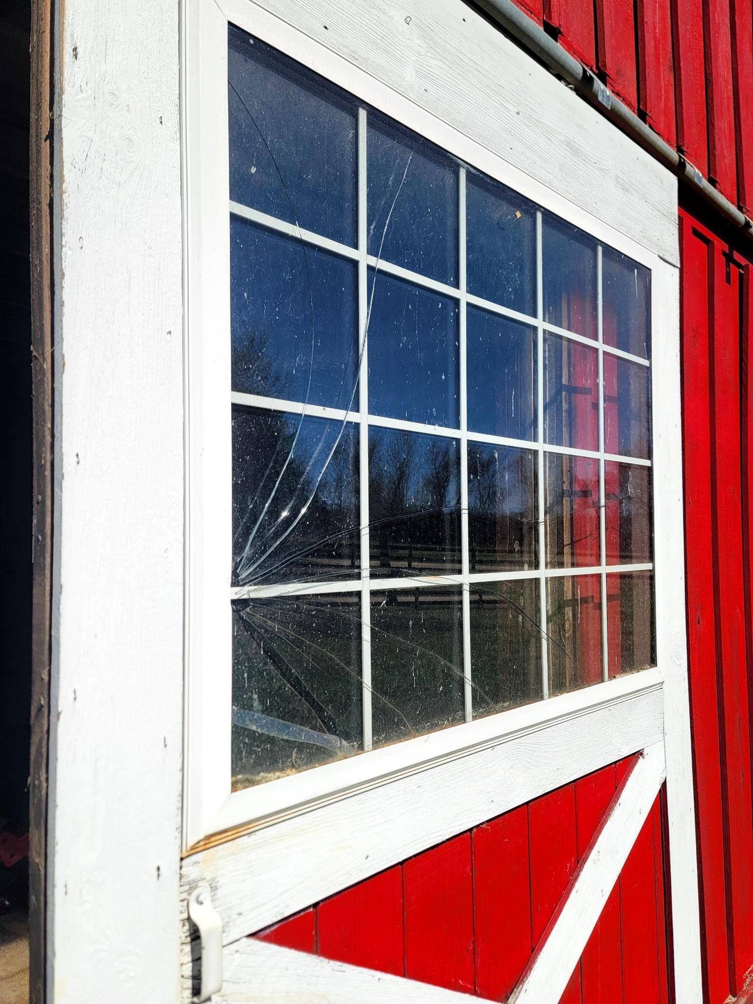 A red barn with a white door and a window