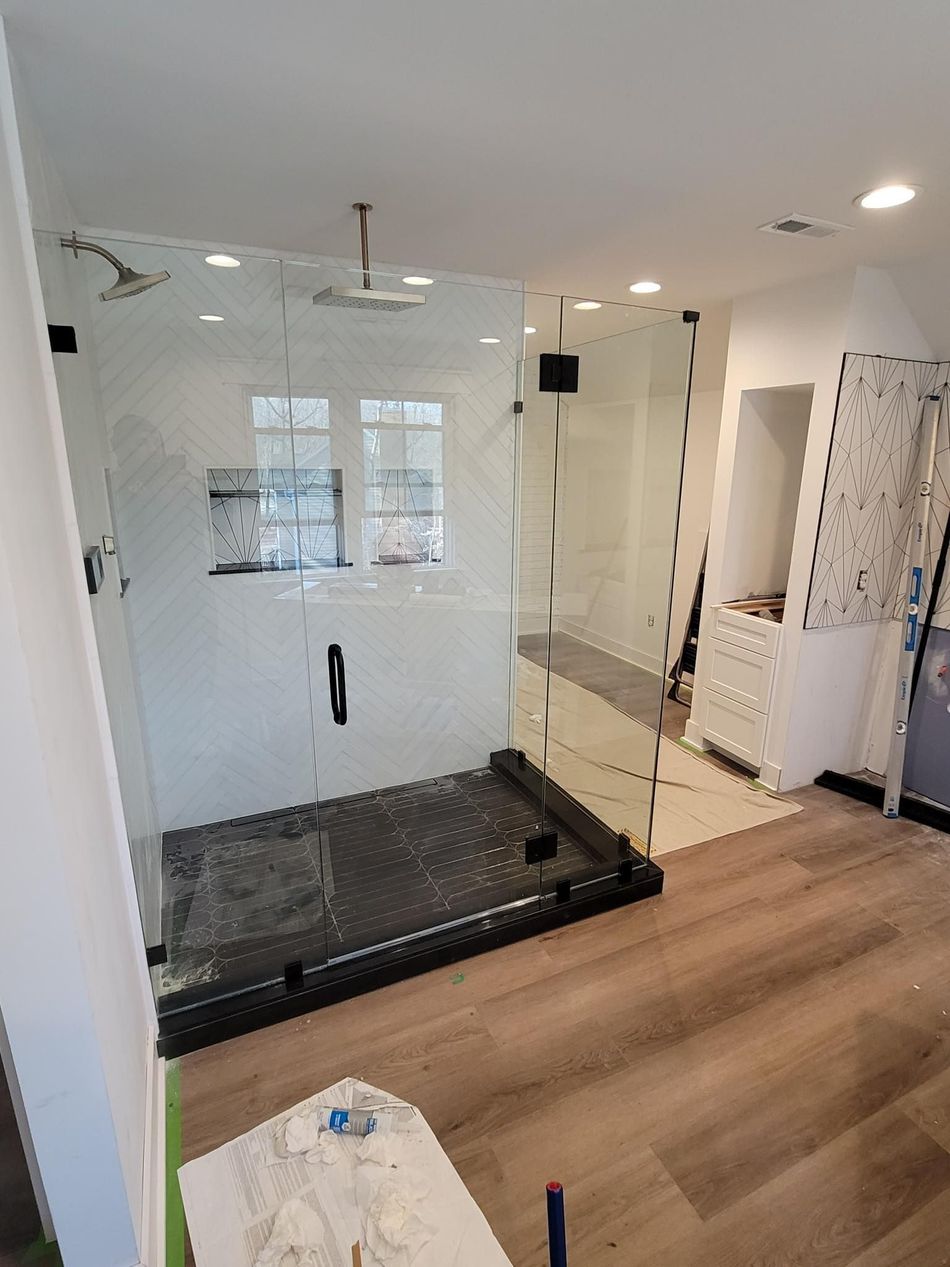 A bathroom with a walk in shower and a glass door.