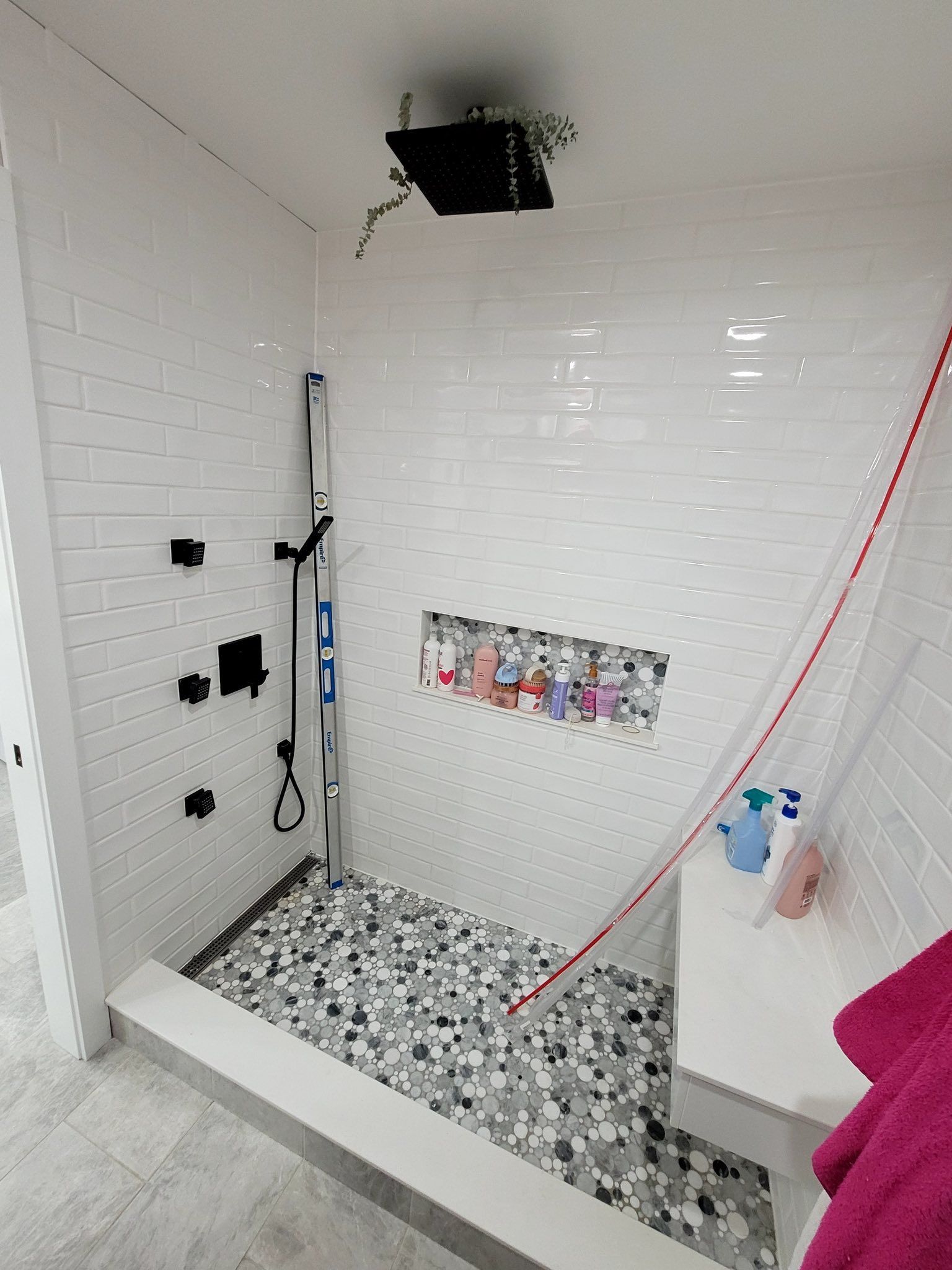 A bathroom with a walk in shower and a sink.