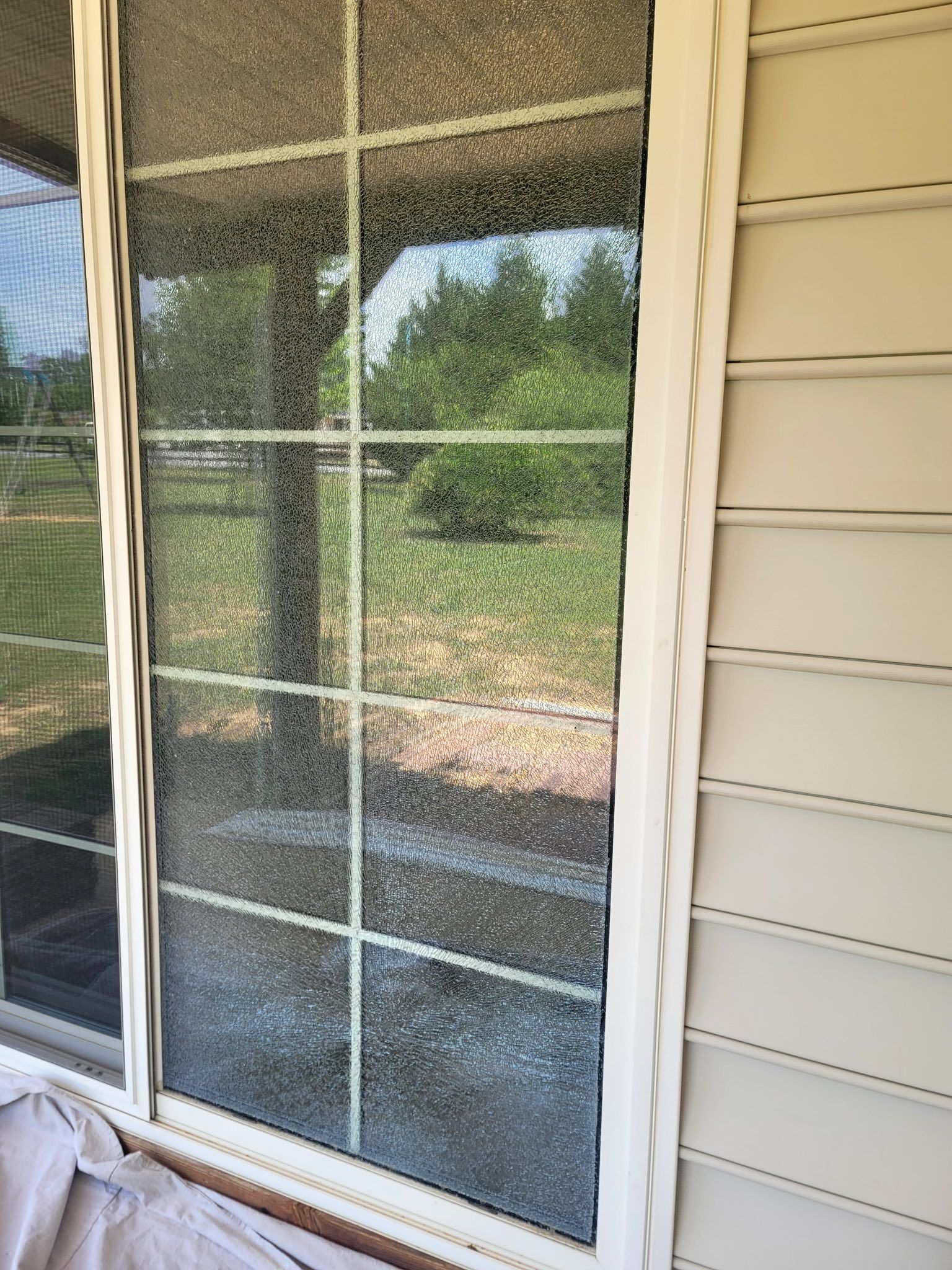 A sliding glass door is sitting on the side of a house.