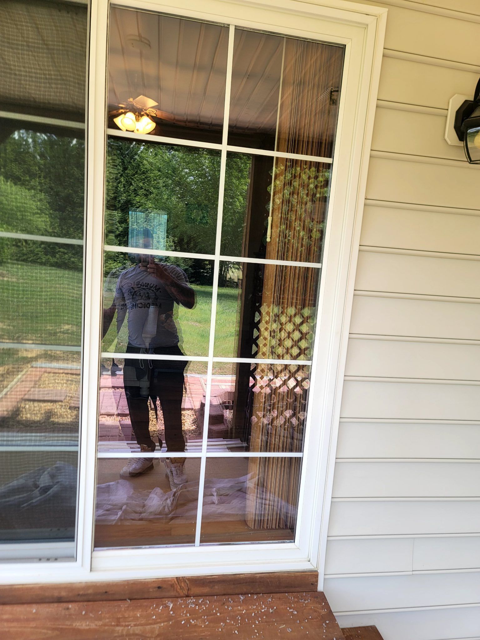 A man is standing in front of a sliding glass door.
