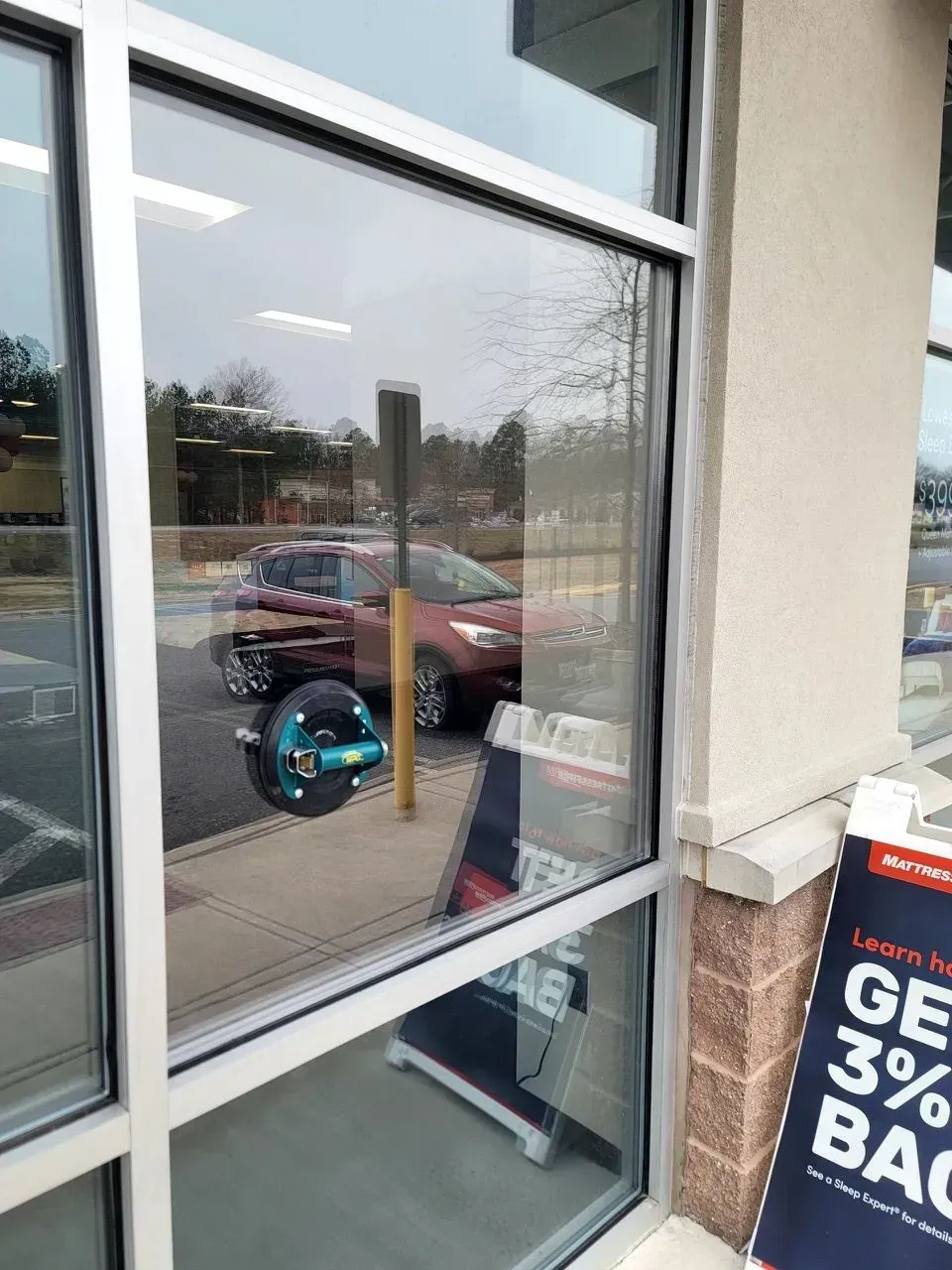 A car is reflected in a window of a building.