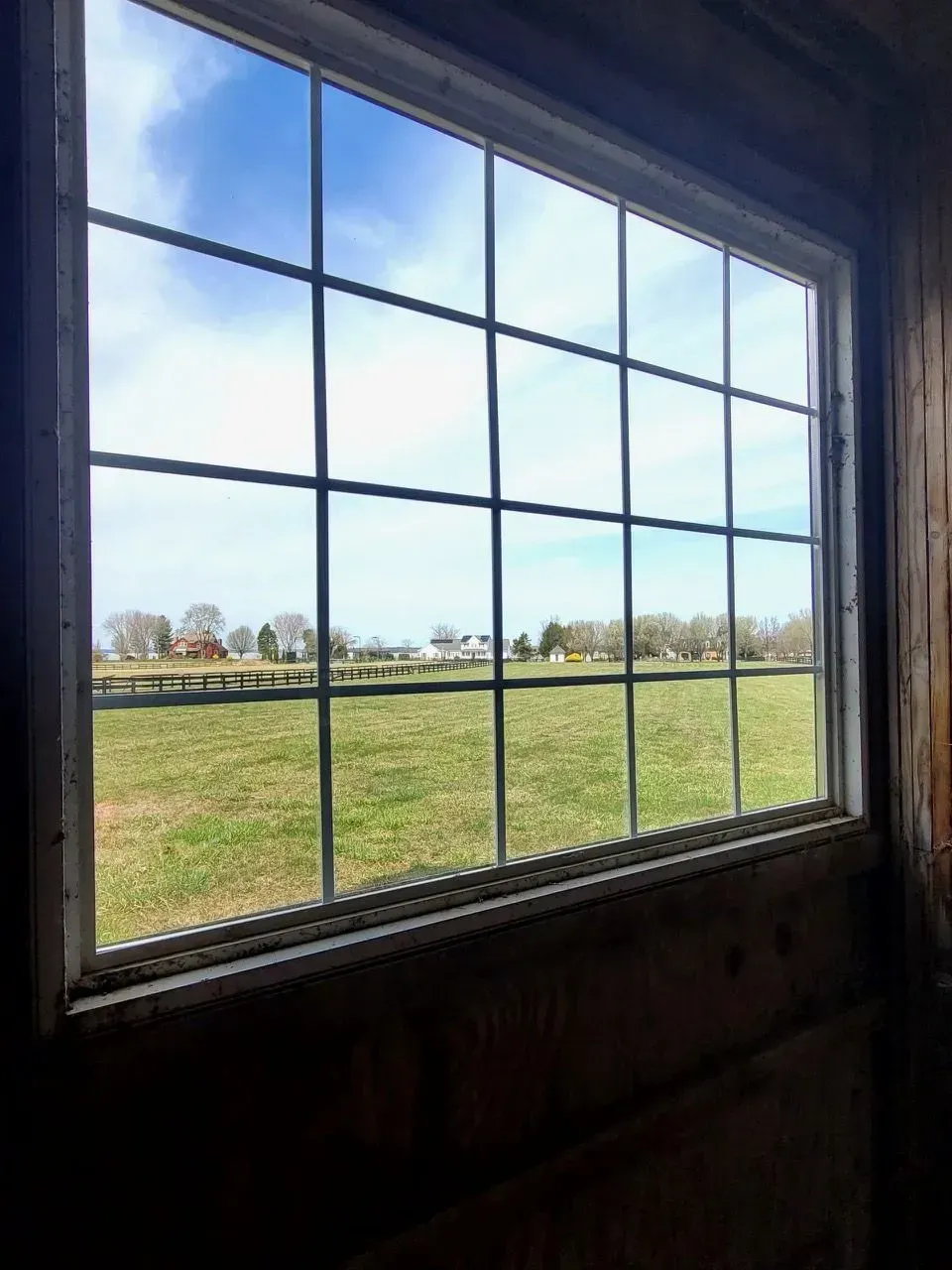 A window with a view of a field in the background