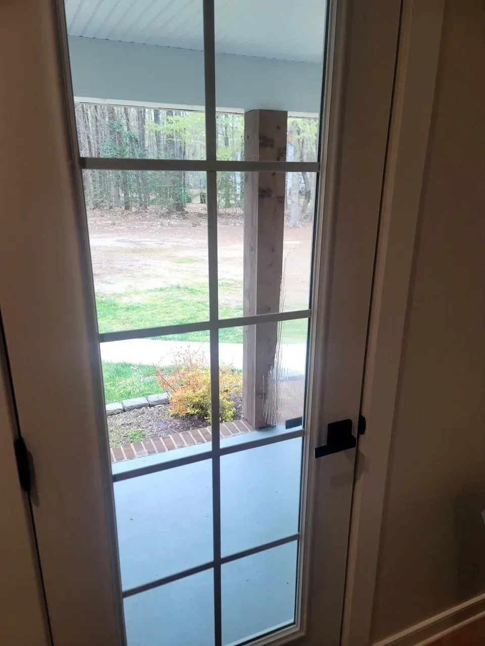 A sliding glass door with a view of a porch.
