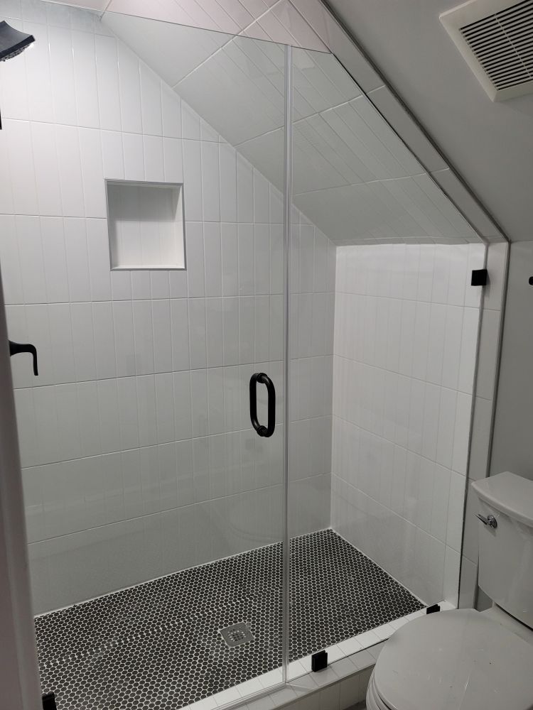 A bathroom with a walk in shower and a toilet.