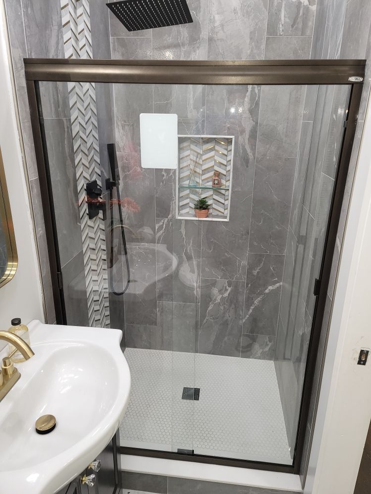 A bathroom with a sliding glass shower door and a sink.