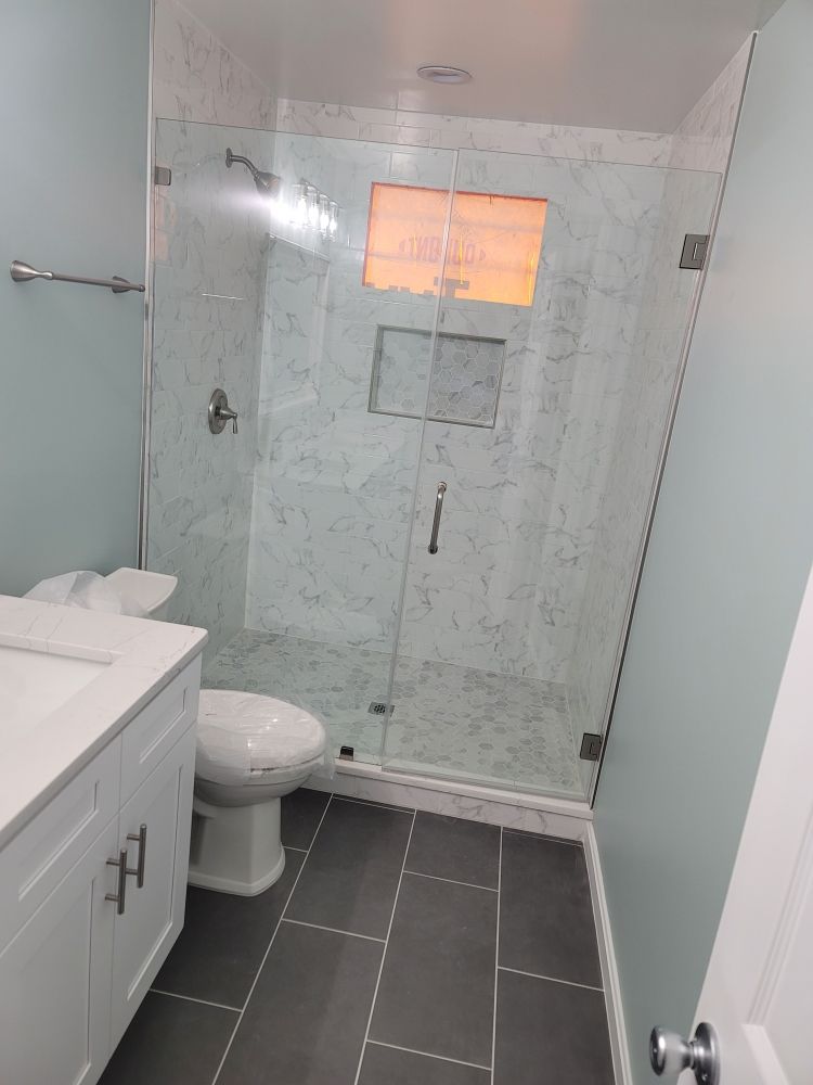 A bathroom with a toilet a sink and a walk in shower