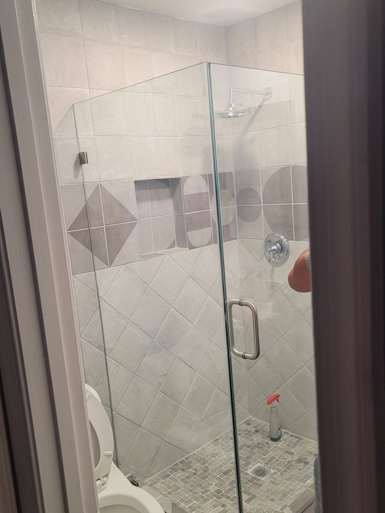 A bathroom with a toilet and a shower with a glass door.