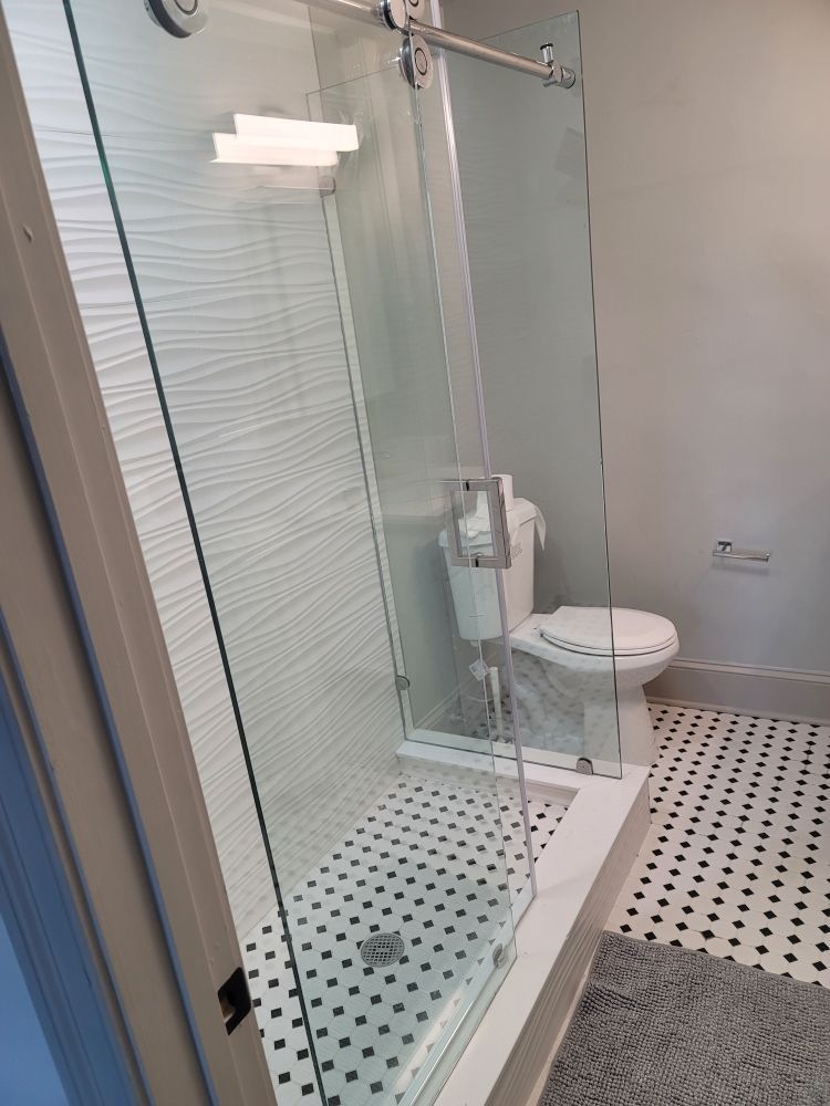 A bathroom with a toilet and a walk in shower.