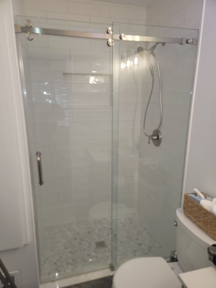A bathroom with a sliding glass shower door and a toilet.