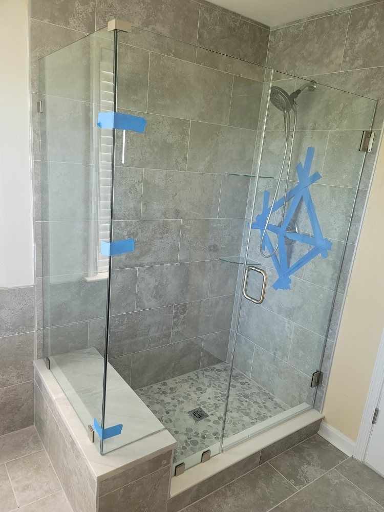 A glass shower door is being installed in a bathroom.