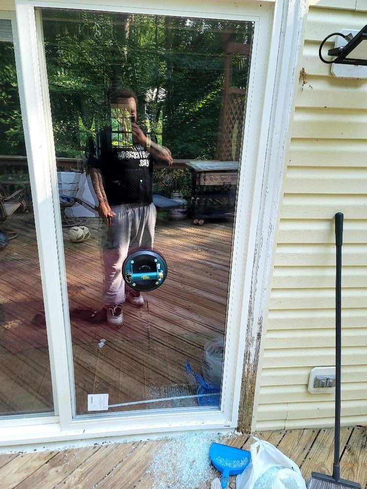 A man is taking a picture of himself in a sliding glass door.