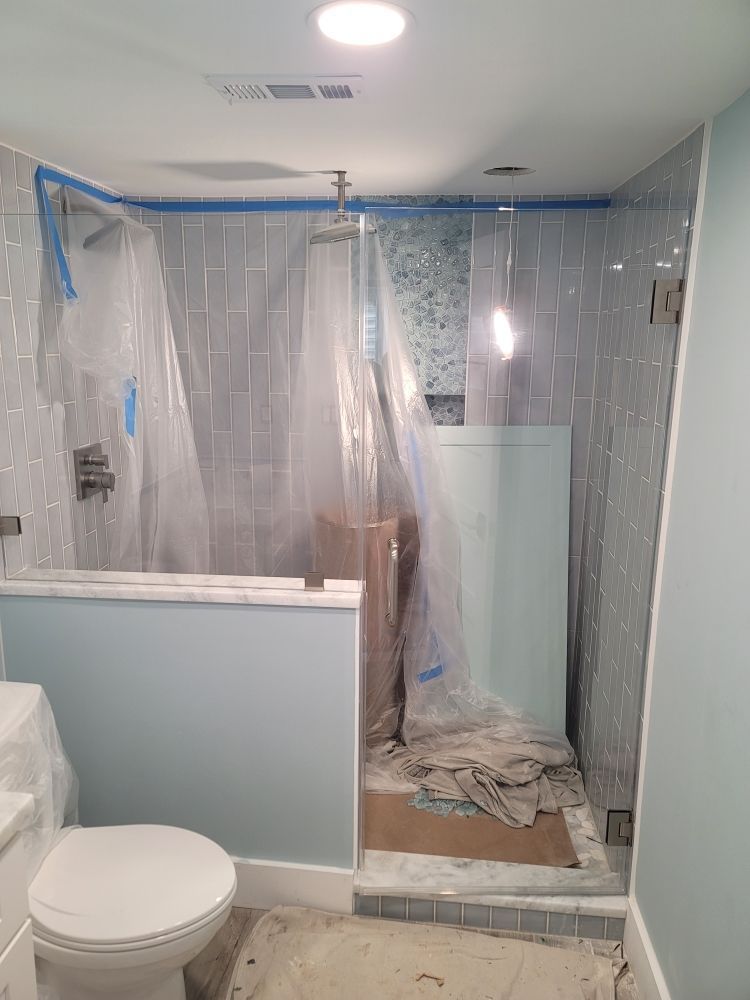 A bathroom with a toilet and a walk in shower.