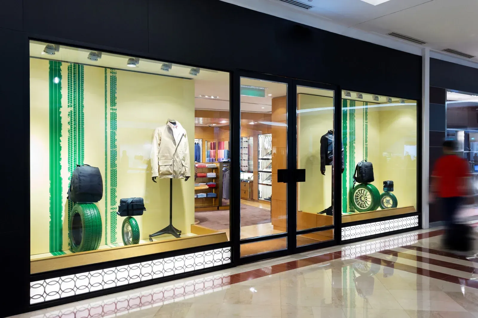 A dog is looking out of a dog door.