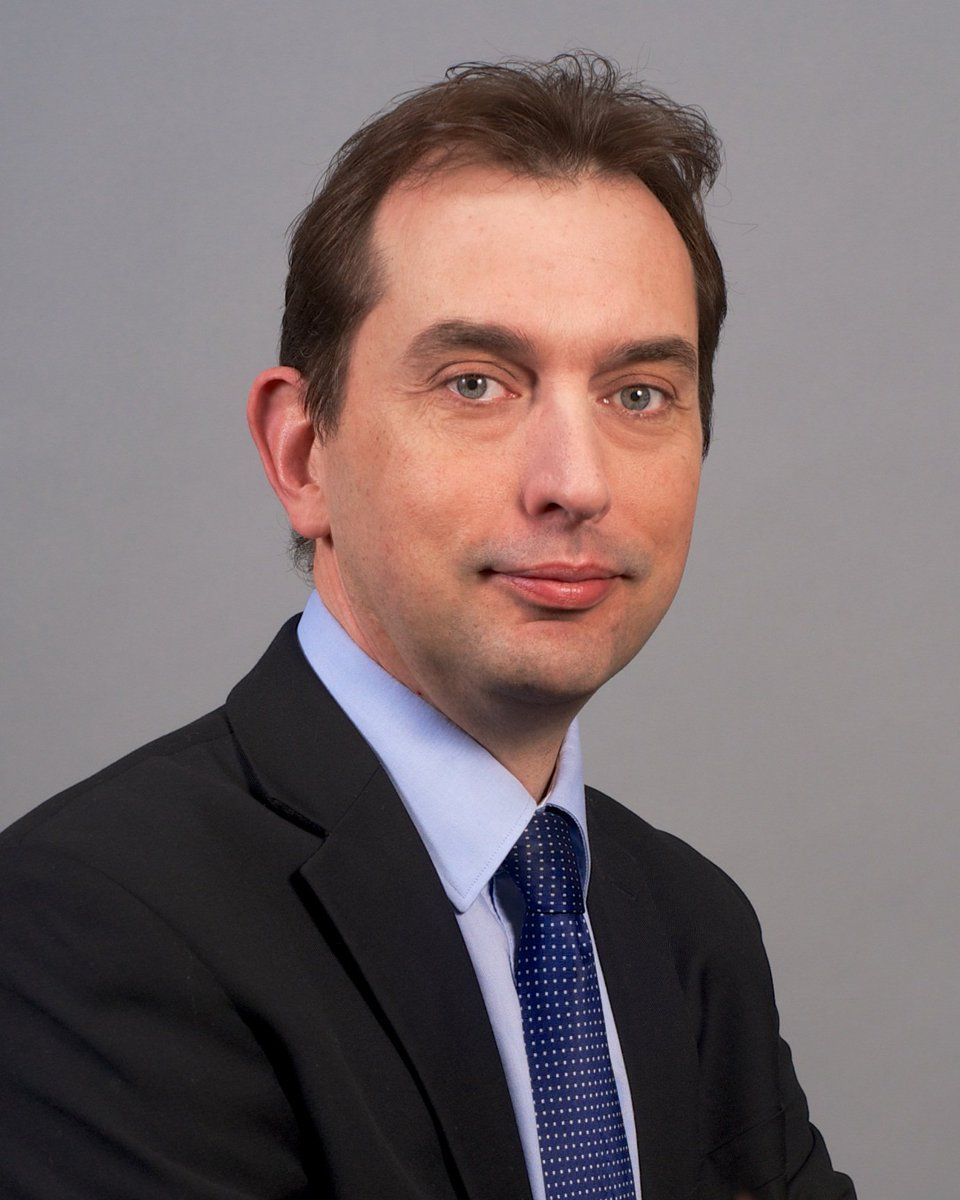 Silhouette of a person, likely male, in a suit jacket, head and shoulders.