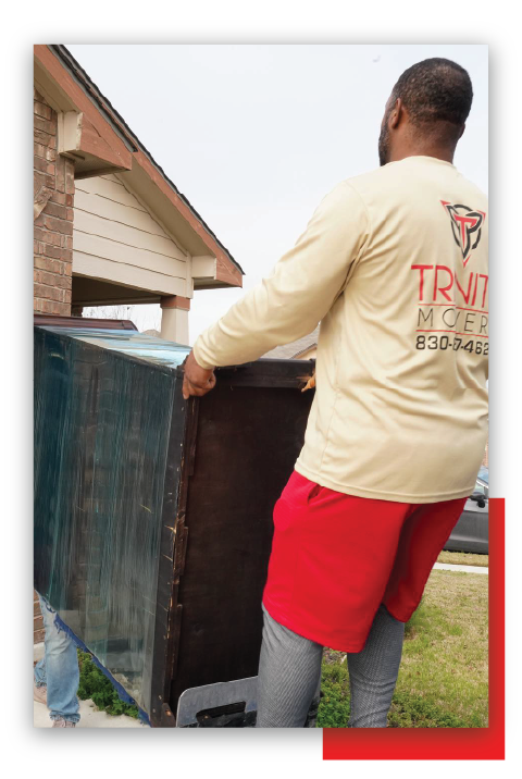 Man Red Shorts Pulling Heavy Box — New Braunfels, TX — Trinity Movers