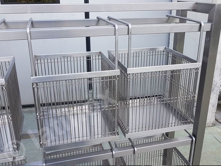 Cestini in rete metallica di acciaio inossidabile appesi a una rastrelliera metallica.