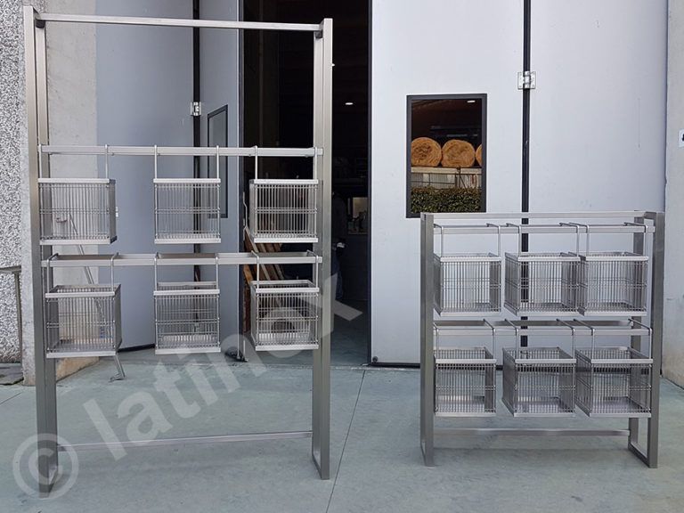 Due scaffalature in acciaio inox, una alta e una bassa, con cestelli metallici quadrati.