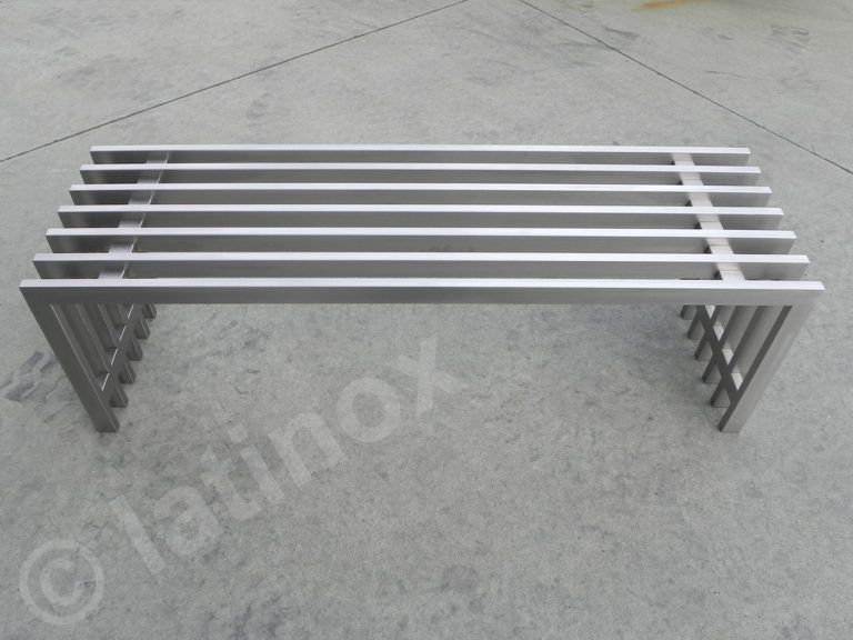 Panca con doghe in acciaio inossidabile su una superficie in cemento.