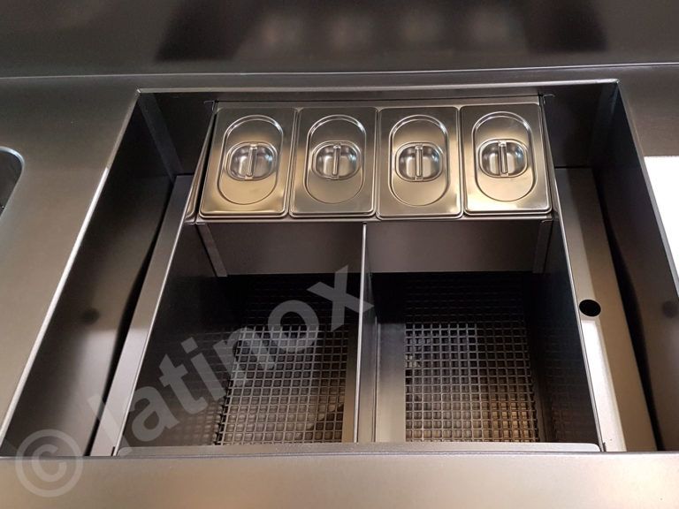 Stazione di preparazione degli alimenti in acciaio inossidabile con quattro contenitori per ingredienti coperti e due contenitori con cestello metallico.