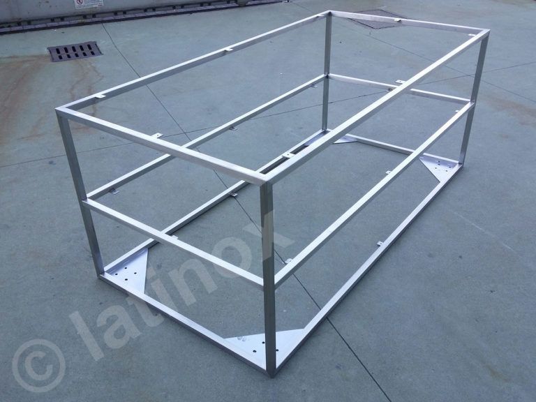 Cornice rettangolare in metallo argentato su una superficie in cemento.