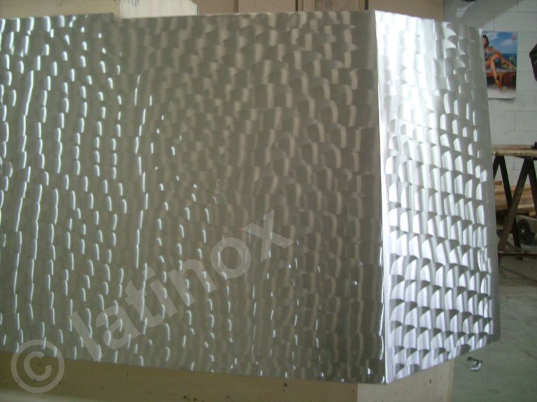 Pannello metallico testurizzato con motivo geometrico, possibilmente in acciaio inossidabile.