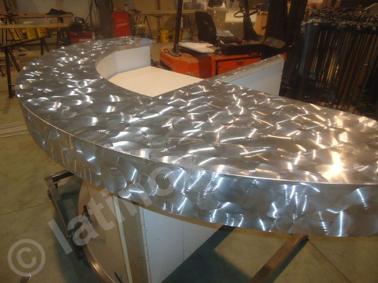 Bancone da bar in metallo con superficie strutturata in un ambiente da laboratorio.