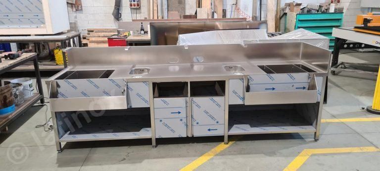 Mobile bar in acciaio inox in un'officina. Contiene lavelli, piani cottura e spazio per riporre gli oggetti.