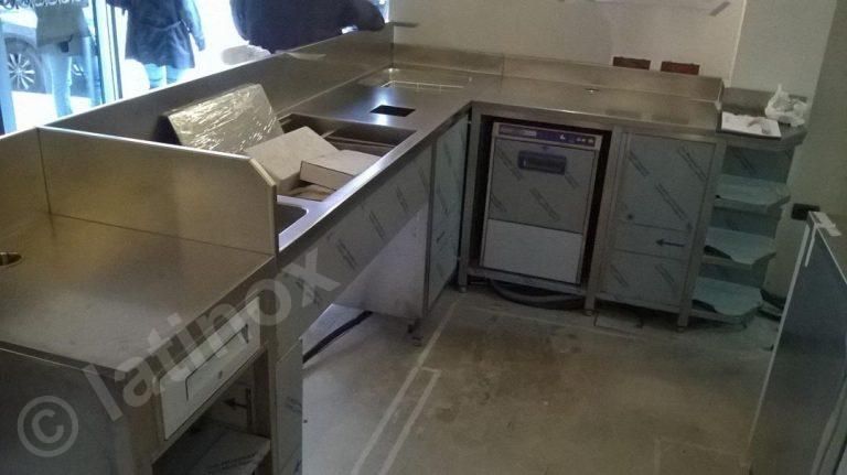Bancone da cucina commerciale in acciaio inox con elettrodomestici e lavelli integrati.