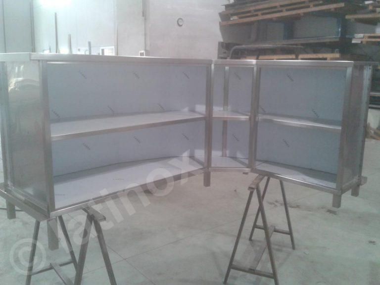 Due armadietti portaoggetti in acciaio inox, dotati di ripiani, sono appoggiati su cavalletti in un'officina.