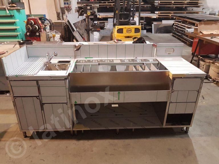 Bar commerciale in acciaio inox con lavello e vaschette per il ghiaccio, al chiuso.
