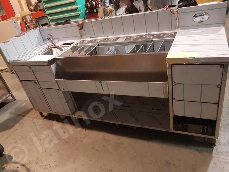 Bancone bar in acciaio inox con lavello, ripiani e armadietti, su ruote.