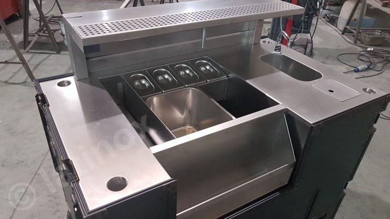 Mobile bar in acciaio inox con scomparti per gli ingredienti e scarico.