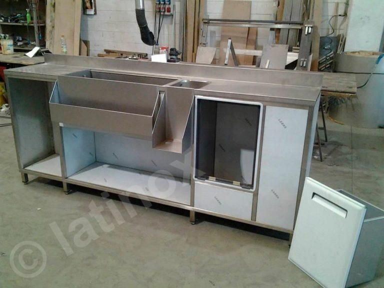 Bar in acciaio inox in costruzione con scomparti aperti e lavello.