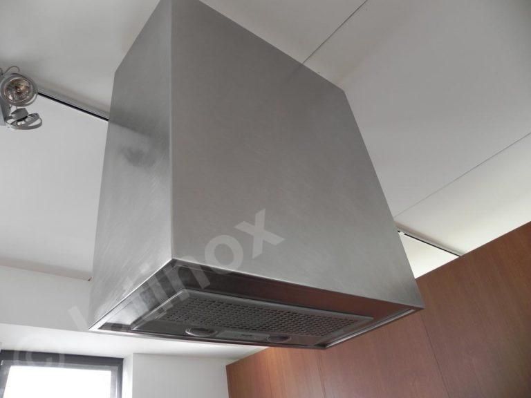 Cappa da cucina in acciaio inossidabile, montata su un soffitto bianco.