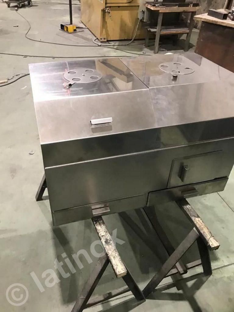 Affumicatore in acciaio inossidabile su cavalletti in un'officina.