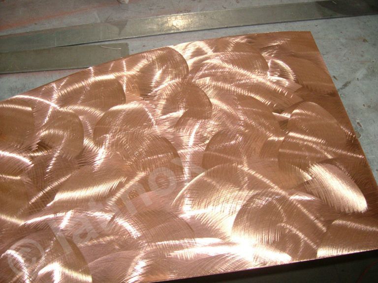 Lamiera di rame con finitura spazzolata e vorticosa che riflette la luce.