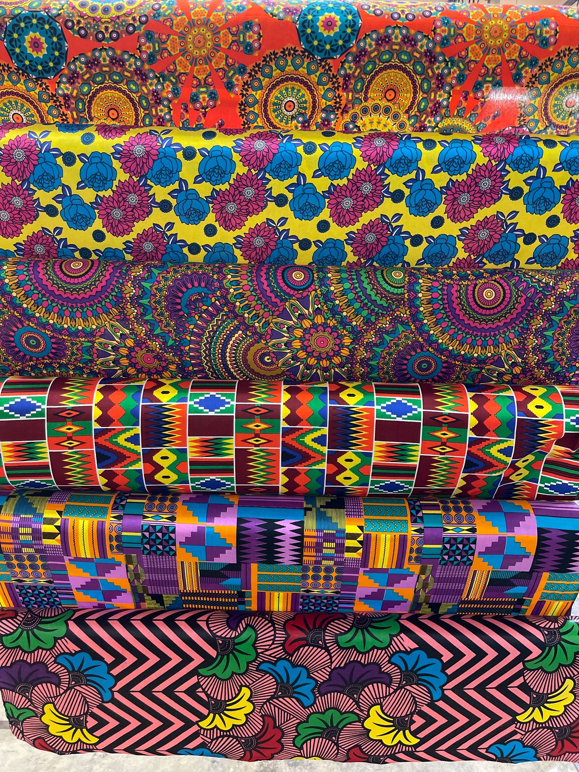 Pile of vibrantly patterned African wax print fabrics.