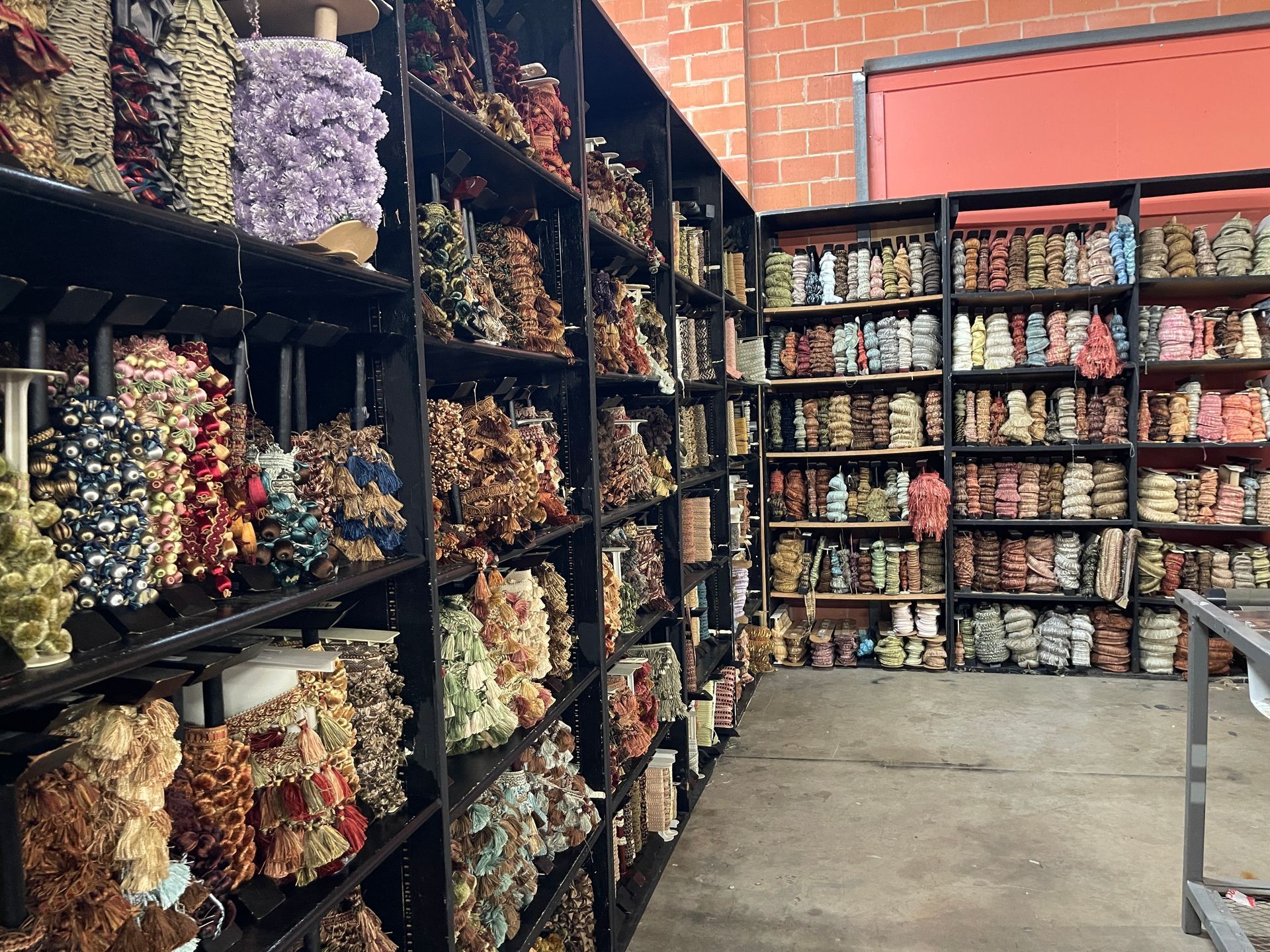 Shelves stocked with numerous colorful, textured coral displays in a warehouse setting.