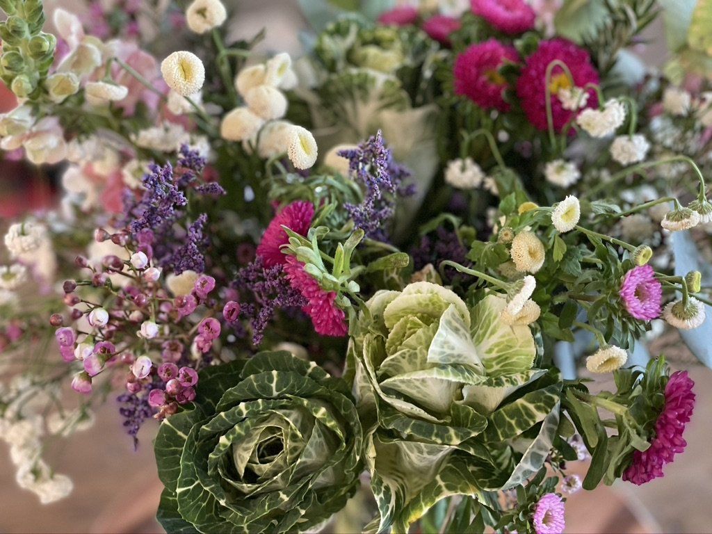 Close-up of a colorful floral bouquet with green, white, purple, and pink blooms. Andrea Lim | Practical Vanity Interiors | Granite Bay, CA | Interior Design