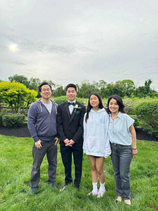 A group of people are posing for a picture in a grassy field.