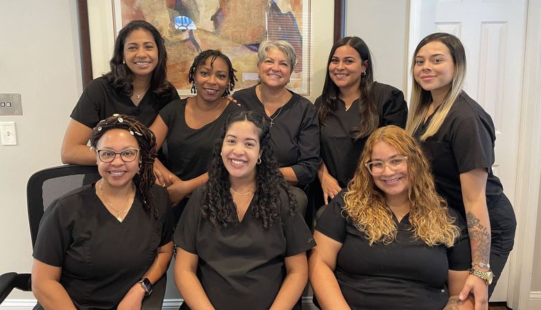 A group of women in scrubs are posing for a picture.