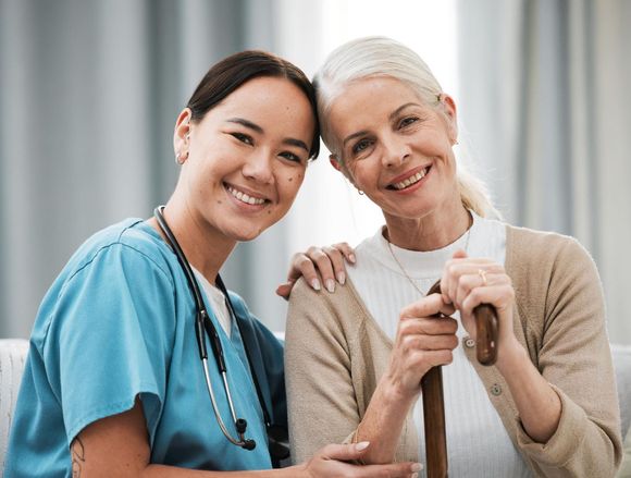 Caregiver and senior woman smiling side by side at Clearstream Rehab