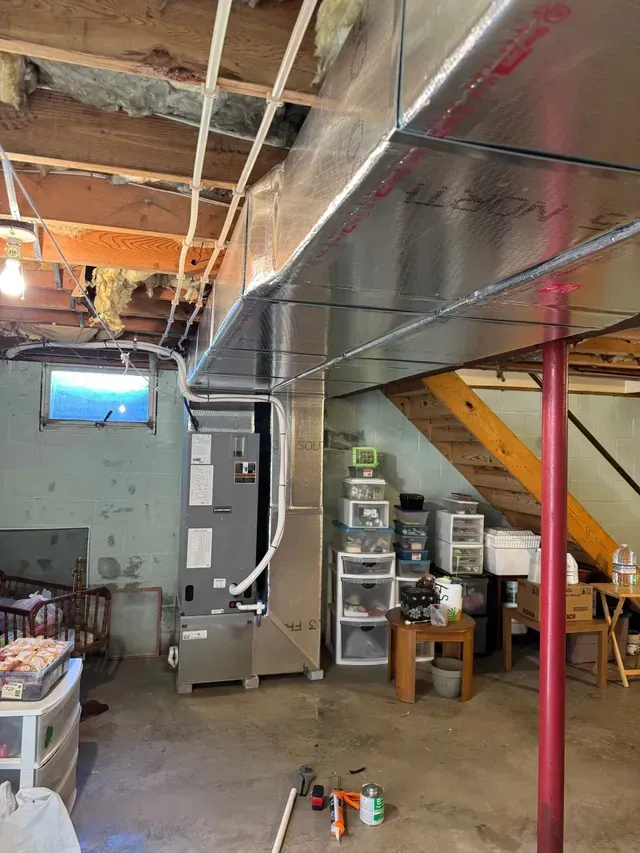 HVAC system in a basement with exposed beams and ductwork.